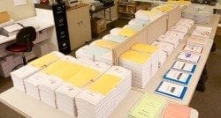 Image of a production room in the Braille Works office with table-tops full of braille materials.