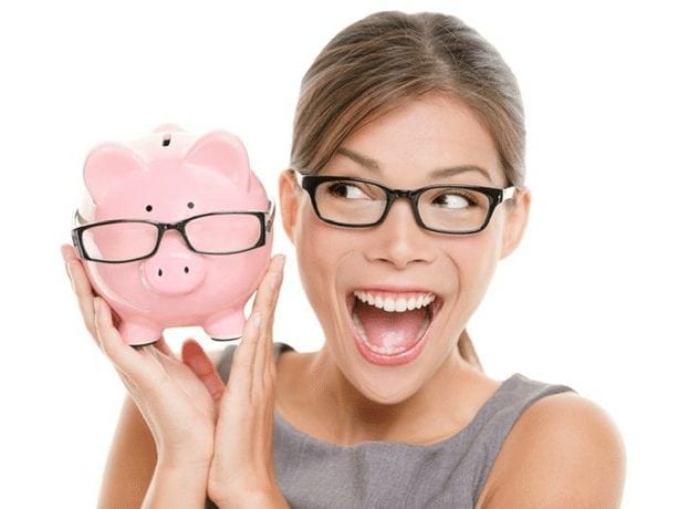 Image of a woman in glasses smiling and holding a pink piggy-bank that also has glasses on. Woman in glasses smiling and holding a pink piggy-bank that also has glasses on.