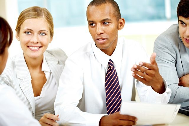 Several business people sitting around a table and talking. Several business people sitting around a table and talking.