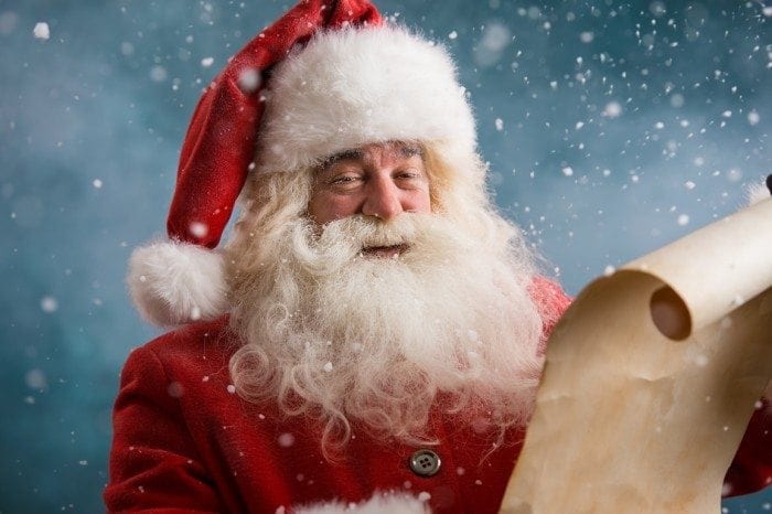 Santa Claus holding a Christmas wish list letter Santa Claus holding a Christmas wish list letter