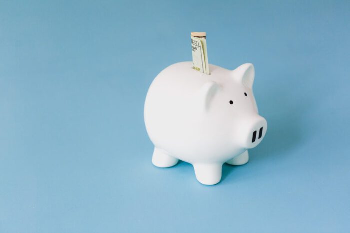 piggy bank with a folded $20 bill sticking up