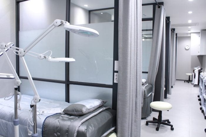 Several hospital beds separated by glass partition walls