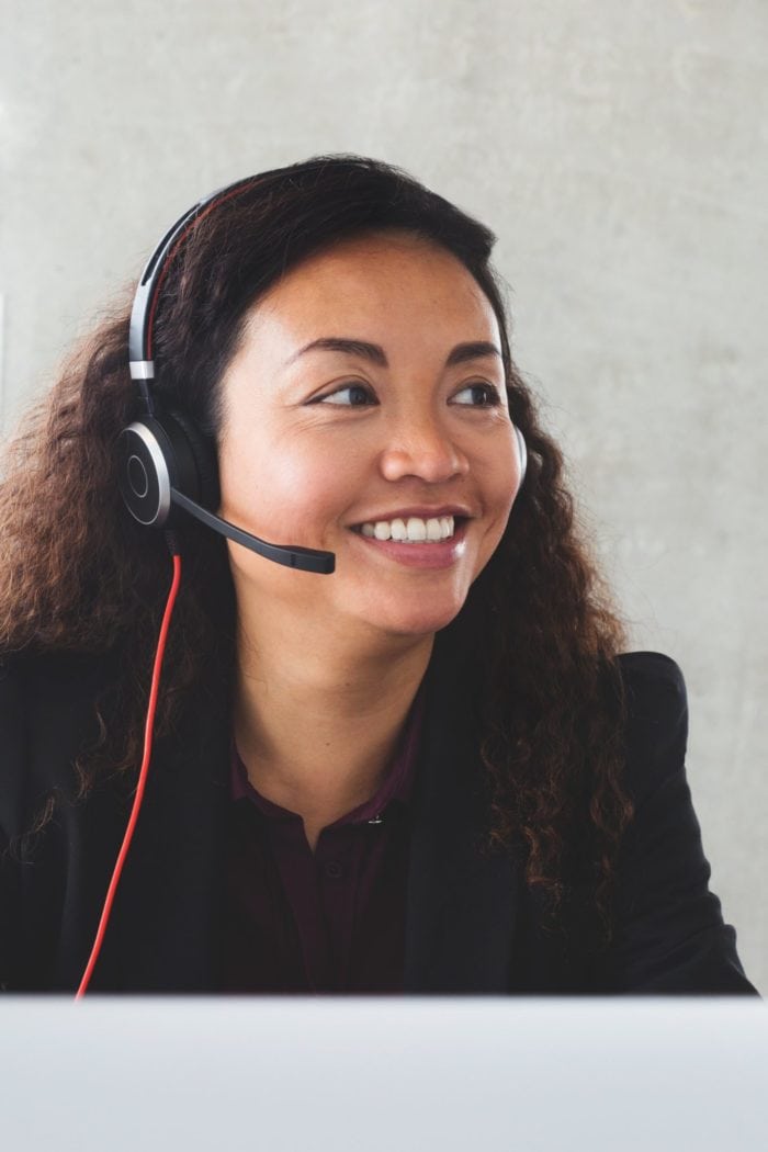 A smiling customer service associate with a headset.