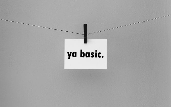 Note card with the text "ya basic." held on a string by a clothespin