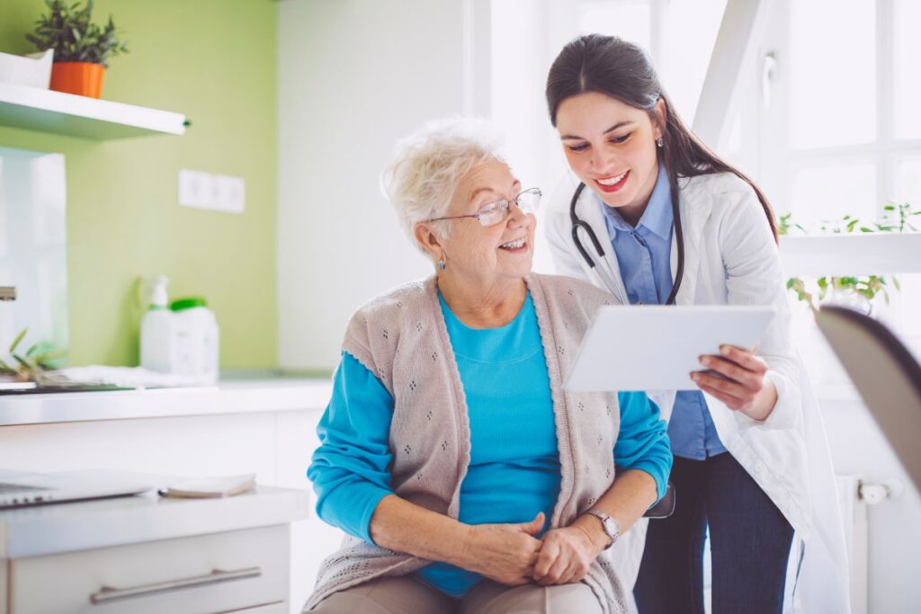 Doctor reviewing paperwork with an elderly patient in a hospital room
